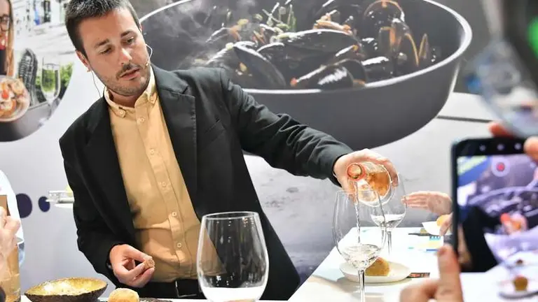 Jorge Rodríguez sirviendo vino en un evento. 