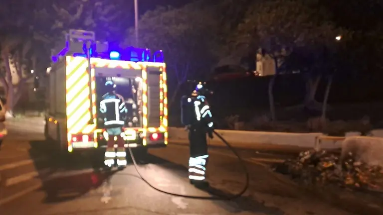 Bomberos del Consorcio de Seguridad y Emergencias apagando las llamas en un contenedor.