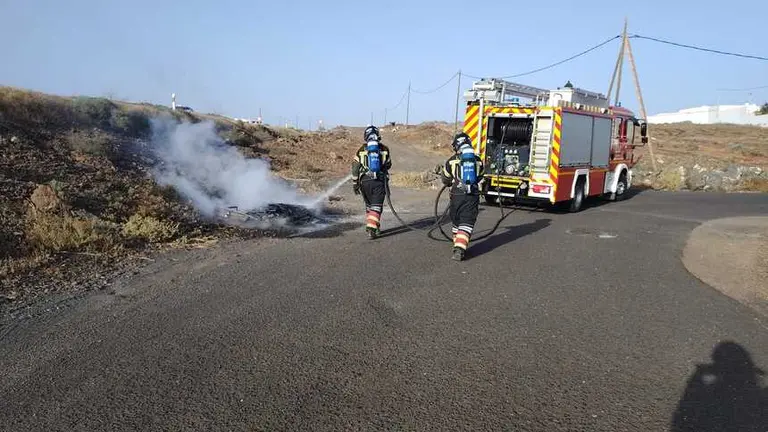 Bomberos sofocando el incendio.