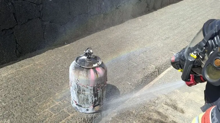 Bomberos del Consorcio enfriando la bombona de gas en la que estaban localizadas las llamas.