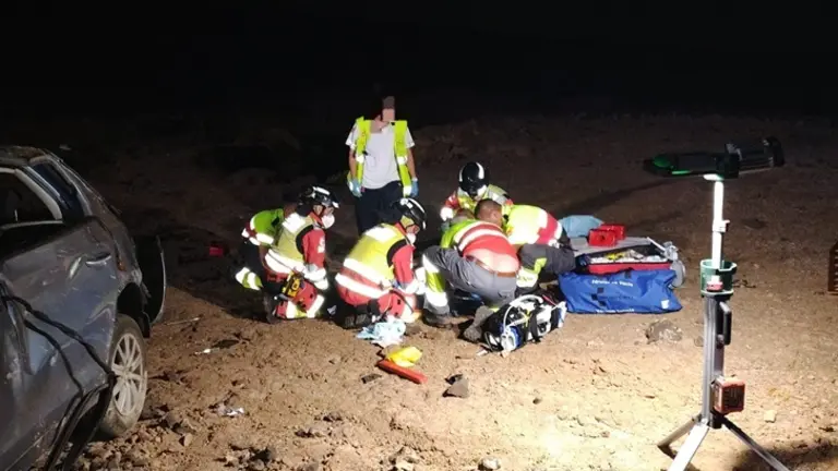 Sanitarios y bomberos atendiendo a uno de los accidentados que se encontraba junto al veh&iacute;culo.