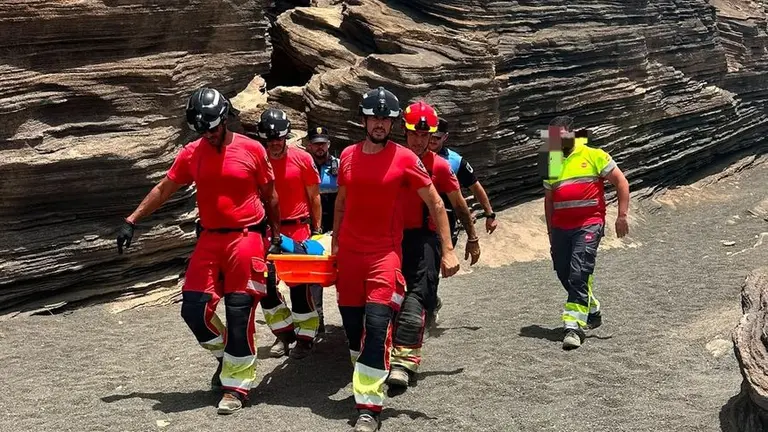 Momento en el que los bomberos y los polic&iacute;as locales trasladan a la persona herida.