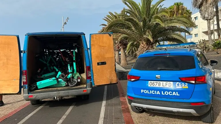 Veh&iacute;culo de la Polic&iacute;a Local junto a las patinetas retiradas.