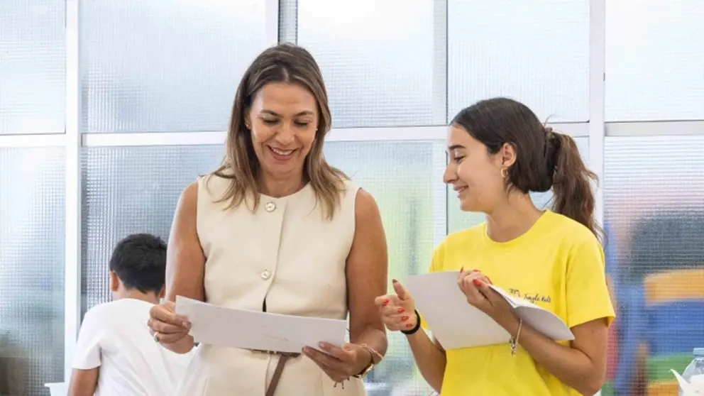 La concejal Maite Corujo con una de las alumnas viendo los trabajos.
