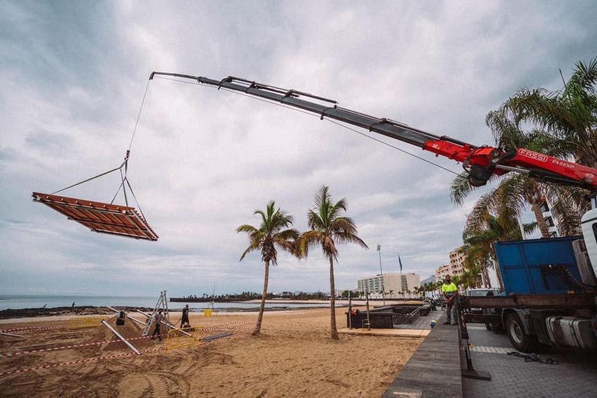 El Ayuntamiento de Arrecife construye una zona de solarium en playa del Reducto destinada a personas con discapacidad. Momento del trasldado de la pérgola