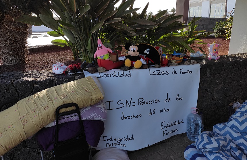 Juguetes del niño y cartel reivindicando la protección de los derechos del niño.