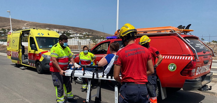 Efectivos del Servicio de Urgencias Canario (SUC) y los bomberos trasladando a la senderista, con el tobillo inmovilizado, hasta la ambulancia.