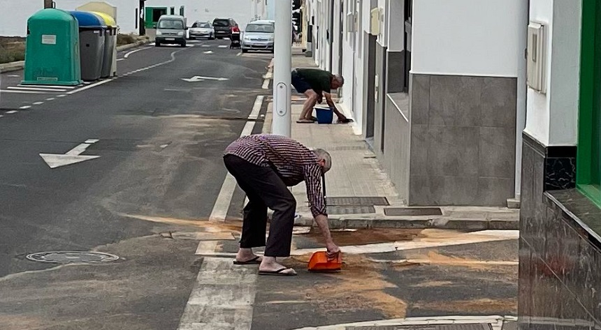 Imagen de los vecinos recogiendo la arena.