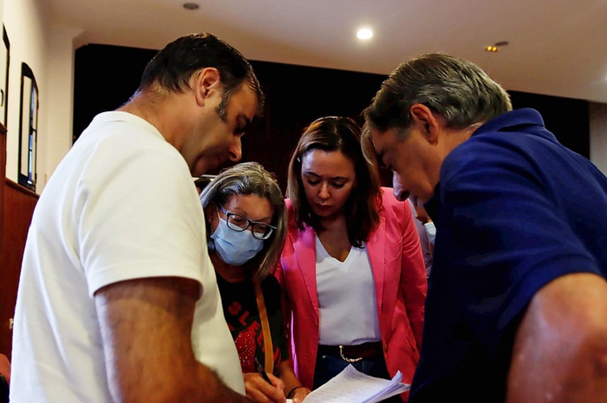 María Dolores Corujo observando un documento junto a los vecinos de Mácher.