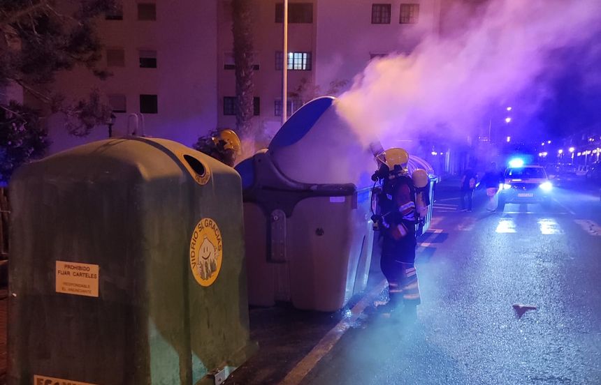 Imagen de los bomberos apagando el fuego del contenedor