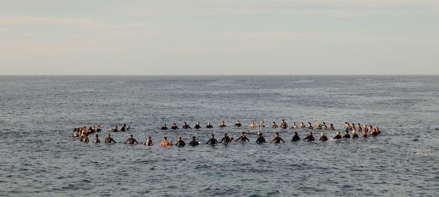 Los surfistas en círculo recordando a su compañero.