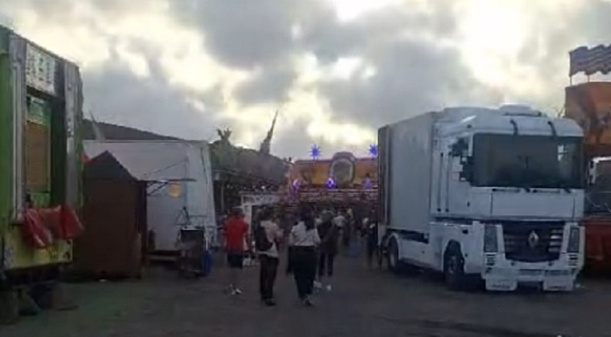 Al fondo de la imagen, mientras actúan los operarios desmontando todo, queda alguna atracción abierta.