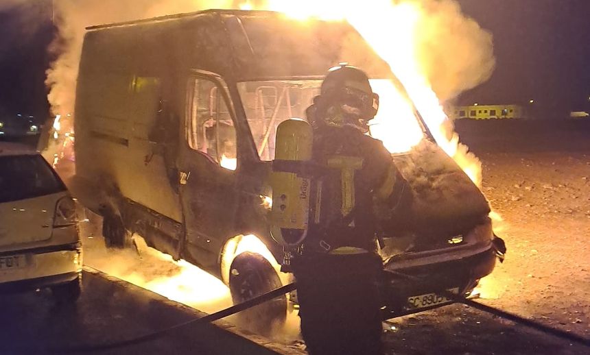 Un bombero sofoca el incendio en la calle Almería.