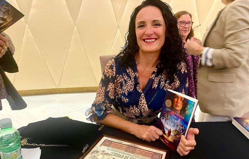 La escritora orgullosa mostrando la portada de su galardonado libro.