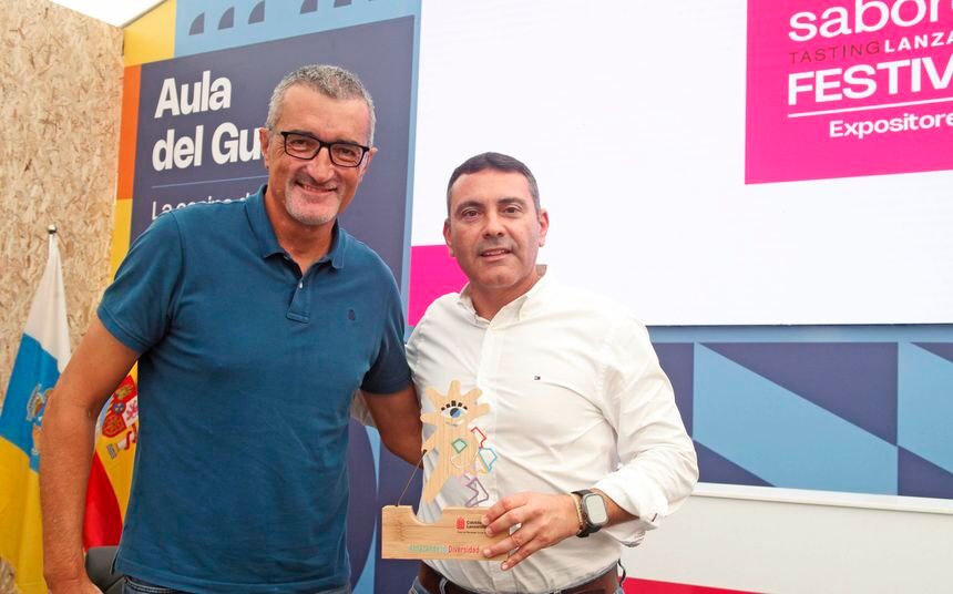 Oswaldo Betancort y Marci Acuña muestran en el recinto de Saborea Lanzzarote un detalle con la figura de la mascota de DIVER