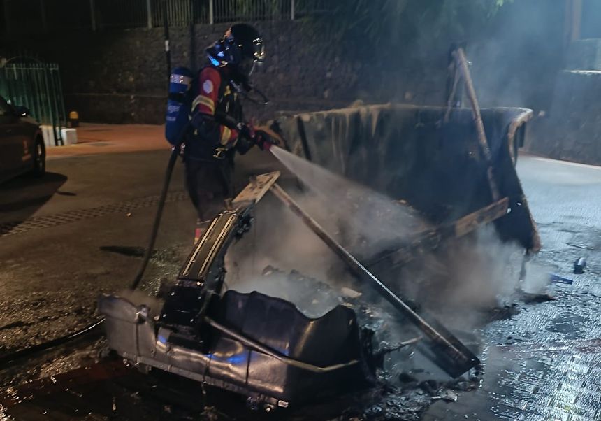 Uno de los bomberos en el momento de terminar de apagar el fuego del contenedor