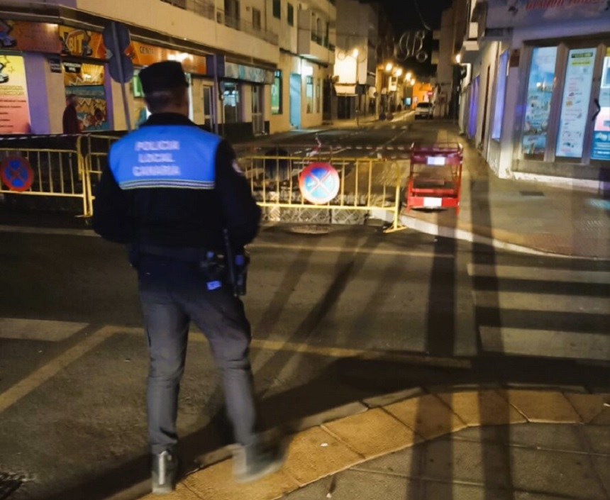 Imagen de un agente de la Policía Local de Arrecife tras el vallado de calles como Portugal. 