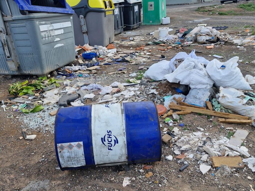 Zona de Argana de unos contenedores con un solar convertido en escombrera
