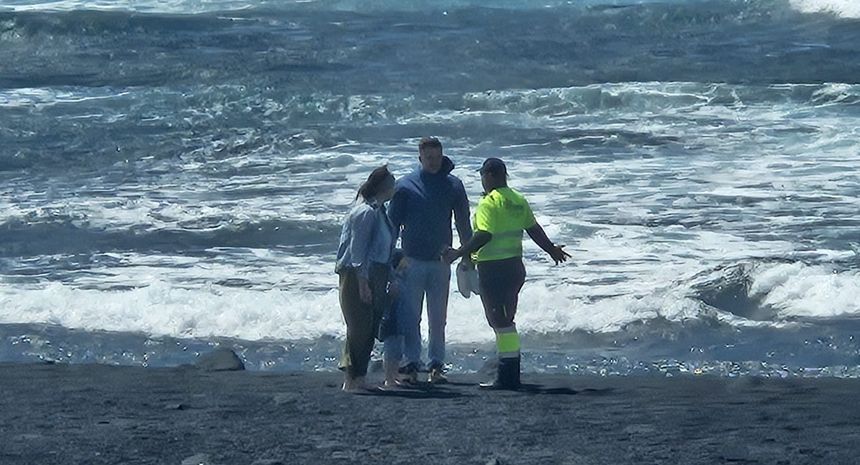 Un operario explicando a una pareja que va con un niño pequeño lo peligroso que era el paseo que estaban dando este sábado por la mañana