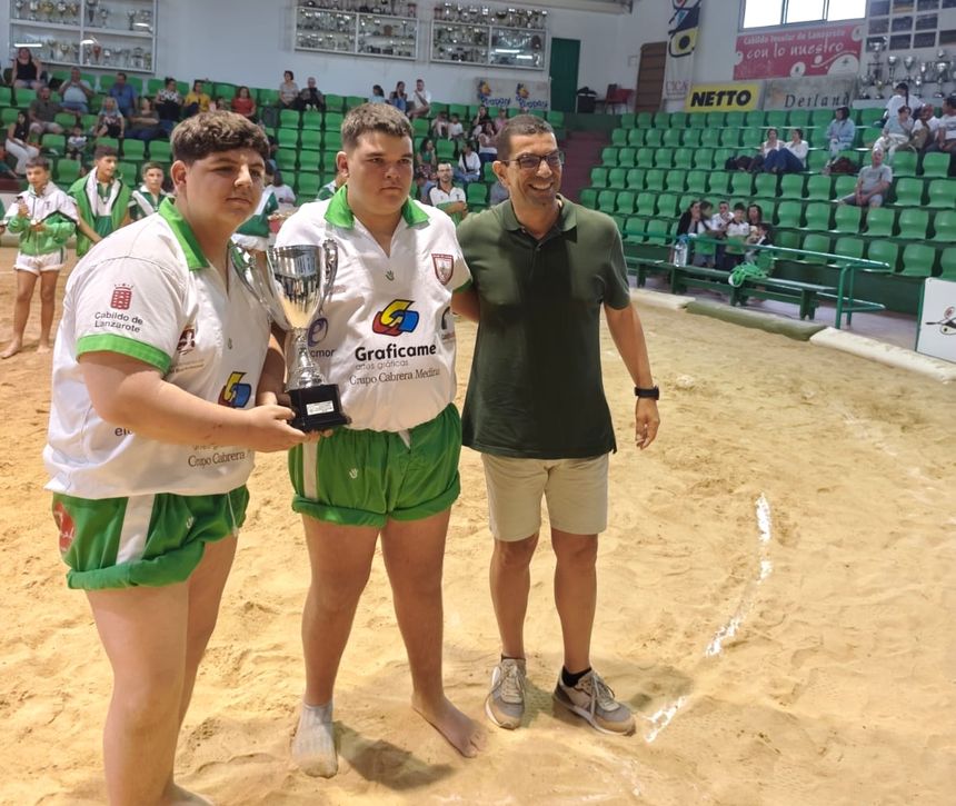 Los luchadores del San Bartolomé infantil recogiendo su trofeo de campeones junto al concejal de Deportes, Alexis Hernández